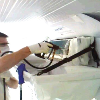Técnico higienizando ar condicionado split instalado na parede
